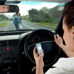 Lady looking at her phone while driving