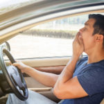 asian man yawning while driving