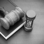 Judge gavel, hourglass and legal book on wooden table, court time concept